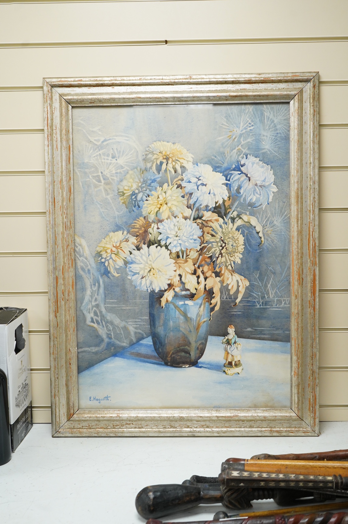 E. Hogarth, Still life of a vase with chrysanthemums and china figures, signed, watercolour, 74 x 51cm